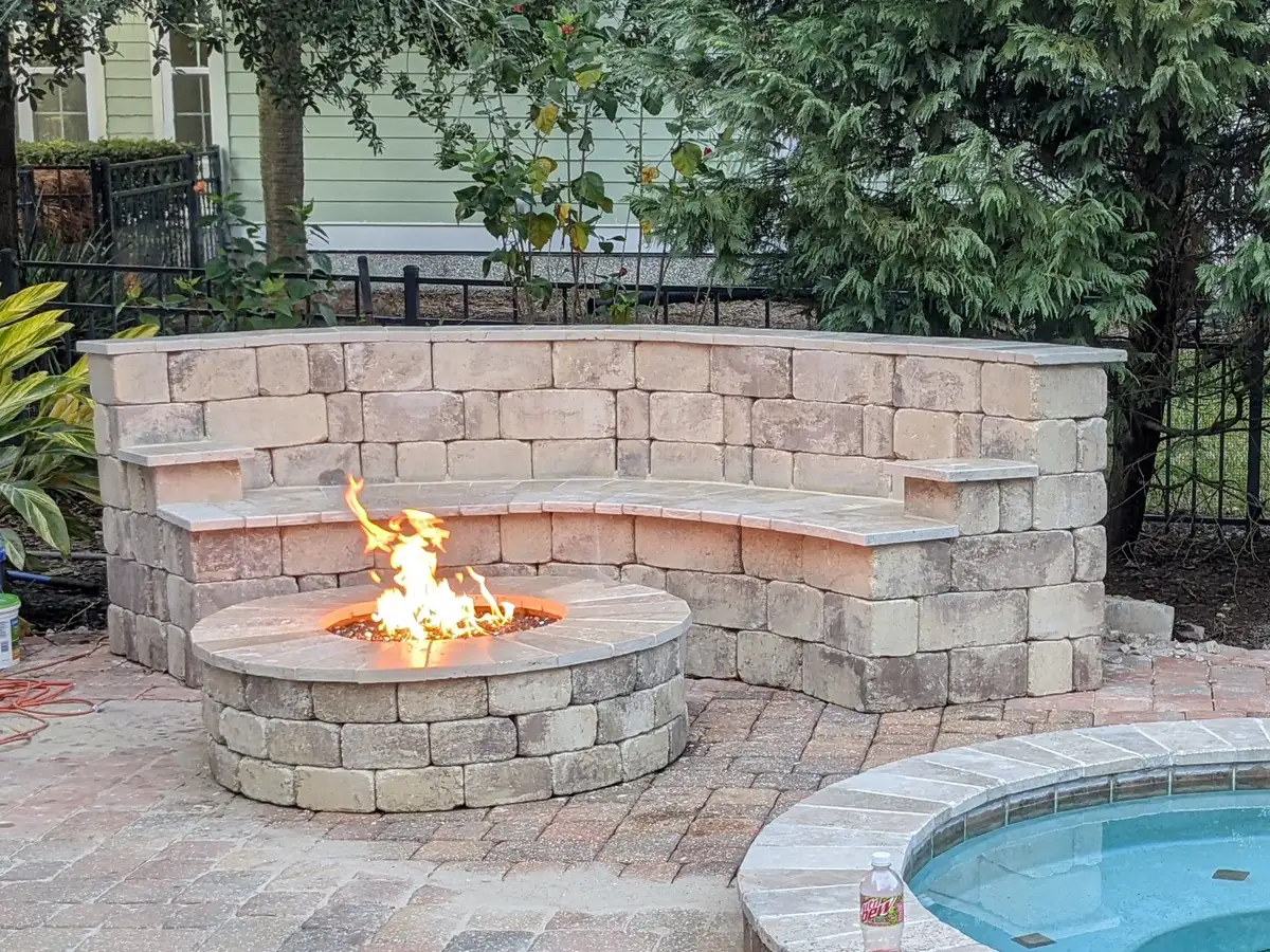 Outdoor fire pit with stone seating area by Bloom and Stone