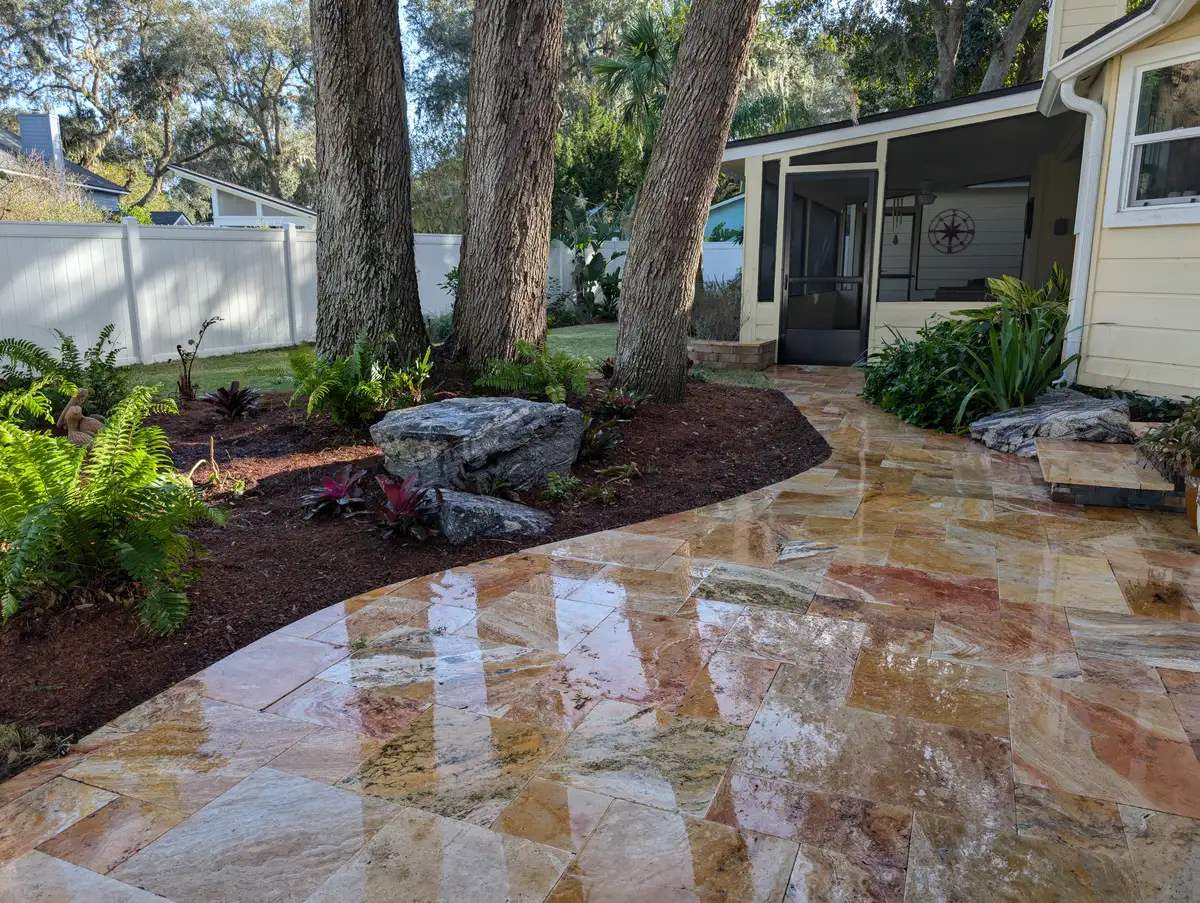 Natural stone patio winding around mature shade trees and layered planting